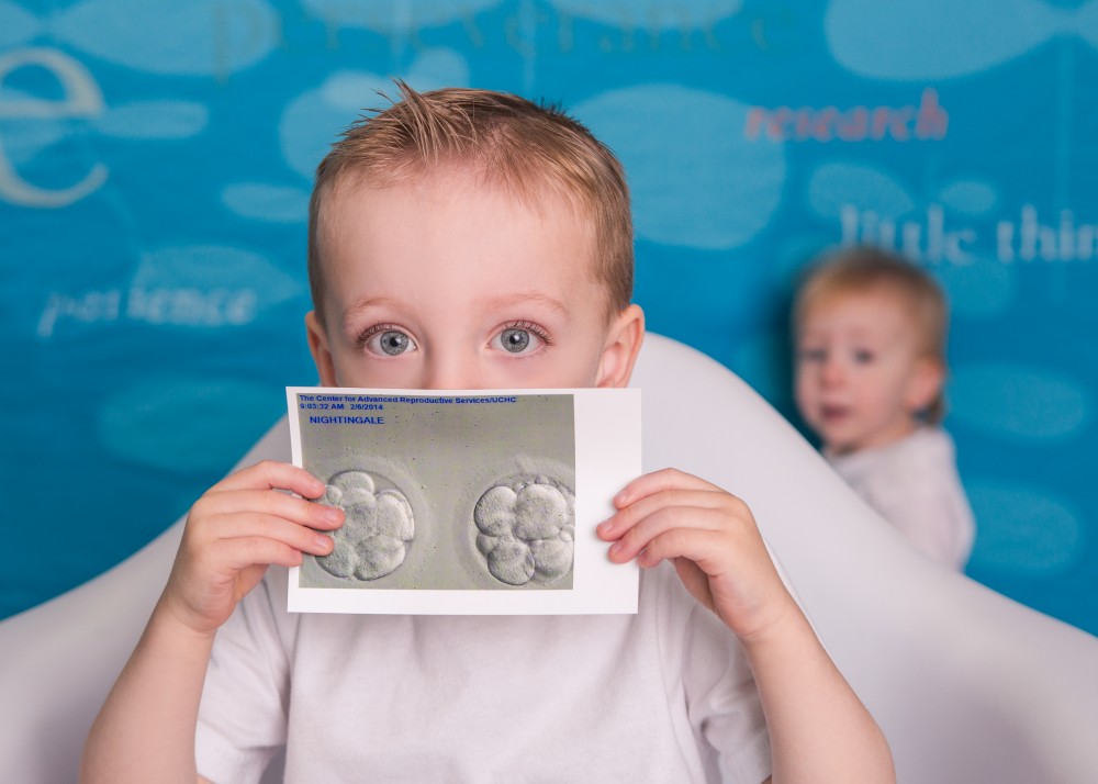 Uconn Fertility success story image of baby and toddler holding embryology image